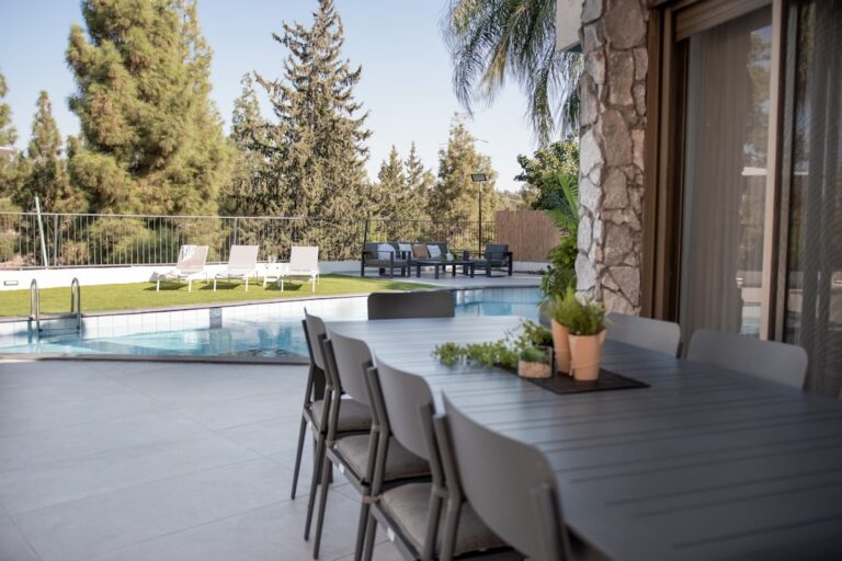 Mesa De Jantar Externa E Cadeiras Ao Lado De Uma Piscina Ph3aYbb4wfE