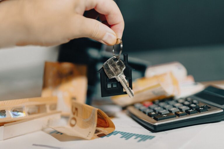 Uma Pessoa Segurando Uma Chave De Casa Na Frente De Uma Calculadora ZZdsJmzuerA