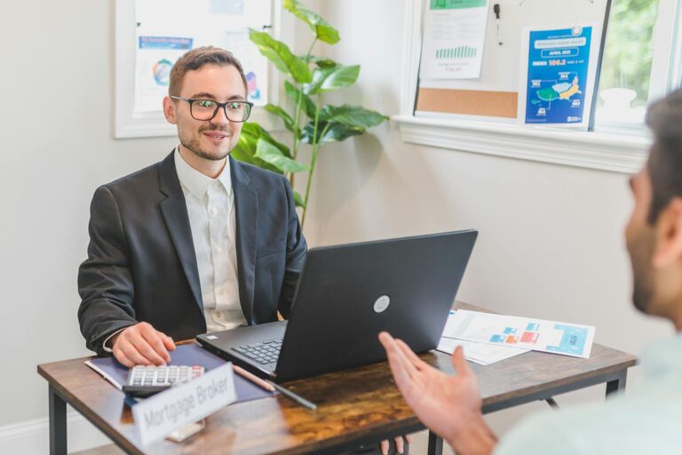 A mortgage broker and client discussing loan options in a modern office setting.