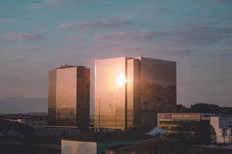 Sunset light reflects on modern glass skyscrapers in Rio de Janeiro, creating a stunning visual effect.