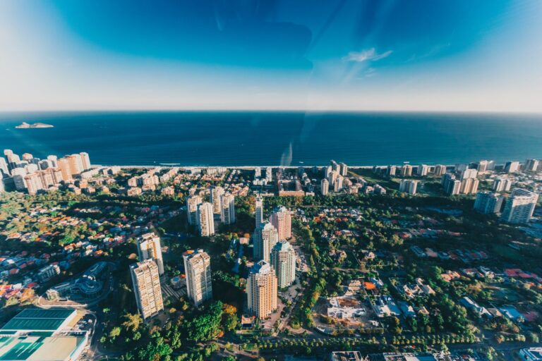 Stunning aerial view of Rio de Janeiro's skyline and ocean horizon under clear skies.