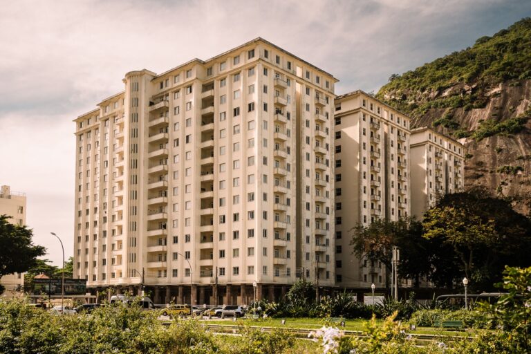 A contemporary residential building in Rio de Janeiro with a scenic mountain backdrop and clear skies.