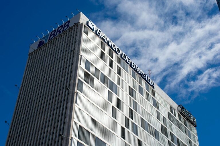 Skyward view of the Banco de Brasília, an iconic modern building in Brazil's capital, under a clear sky.