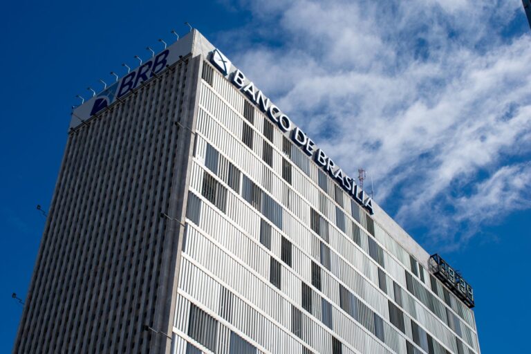 Skyward view of the Banco de Brasília, an iconic modern building in Brazil's capital, under a clear sky.
