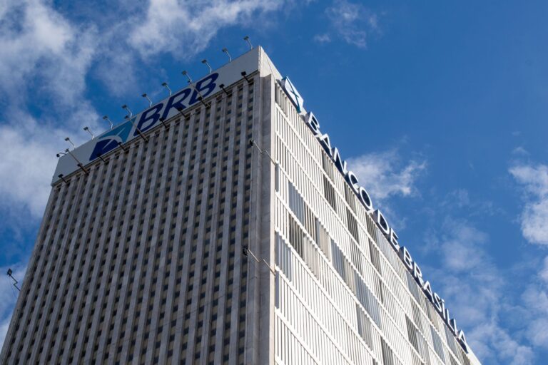 High-rise Banco de Brasília building with clear sky, capturing modern architecture against a vibrant blue background.