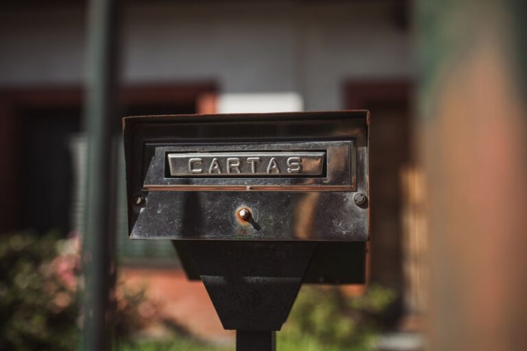 Close-up of an outdoor mailbox with 'Cartas' label in a sunny setting.