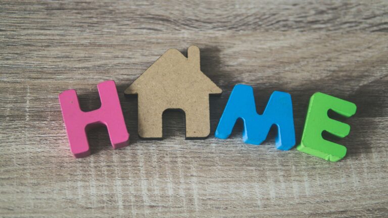 Colorful wooden letters spelling 'HOME' on a wooden surface, representing warmth and domesticity.
